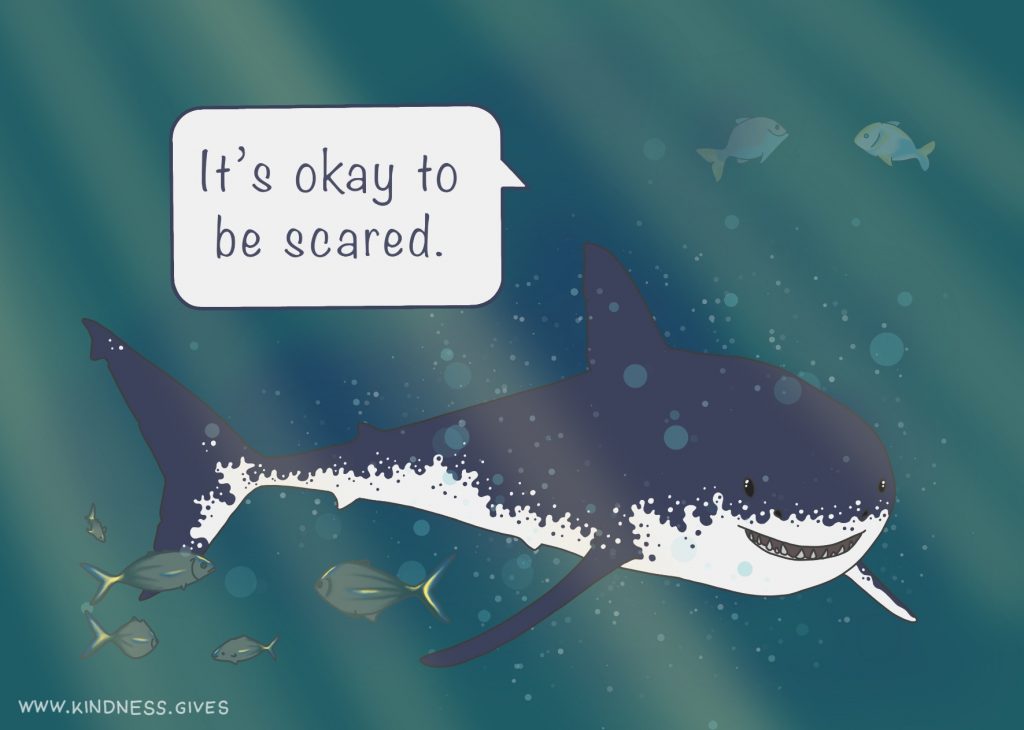 A friendly smiling shark saying "It's okay to be scared."